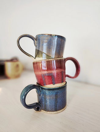Handmade pottery mugs arranged on a table